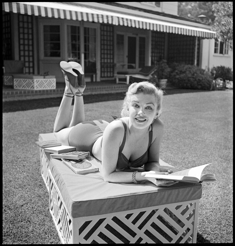 Marylin Monroe, chez elle, lisant des livres, l'une de ses passions.